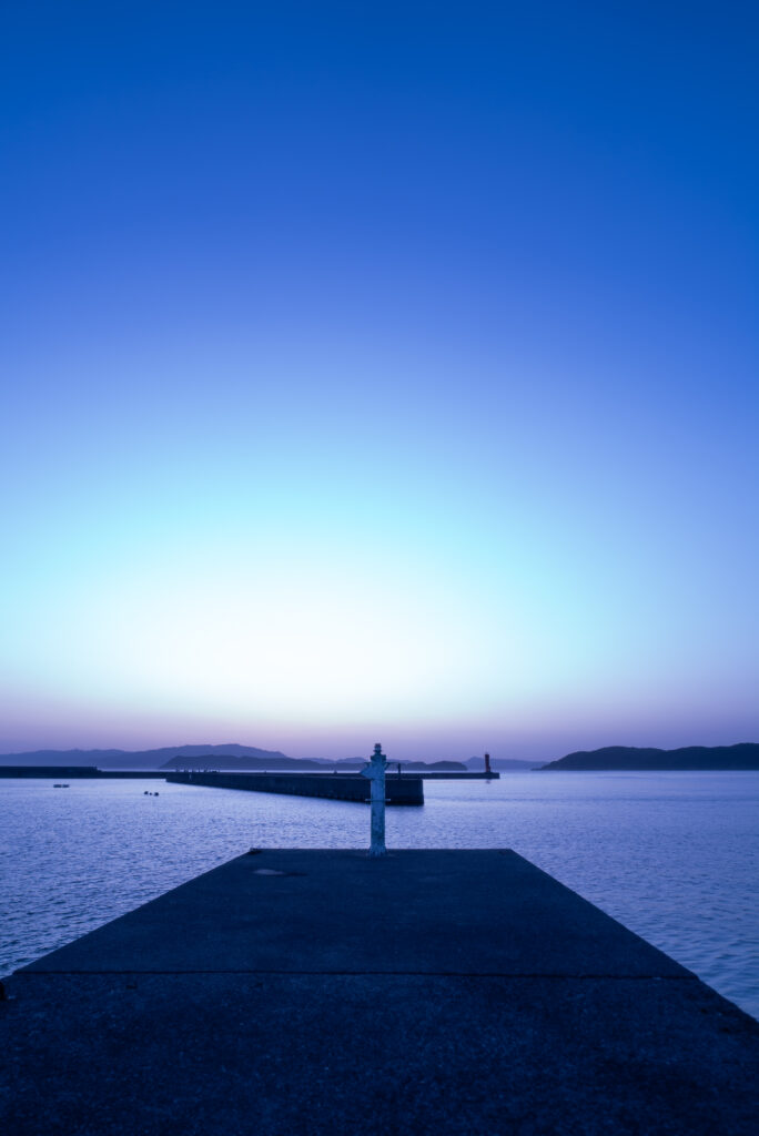 日没後の静かな加太港の白灯台